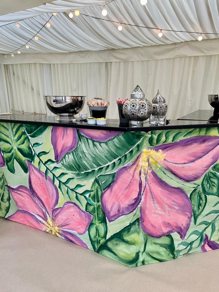 Hand-painted tropical floral bar front set up inside a marquee
