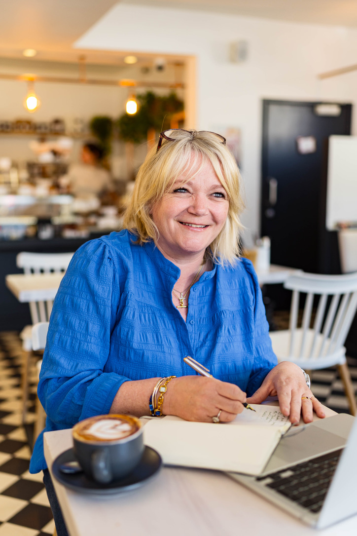 Charlie smiling while working in a bright cafe