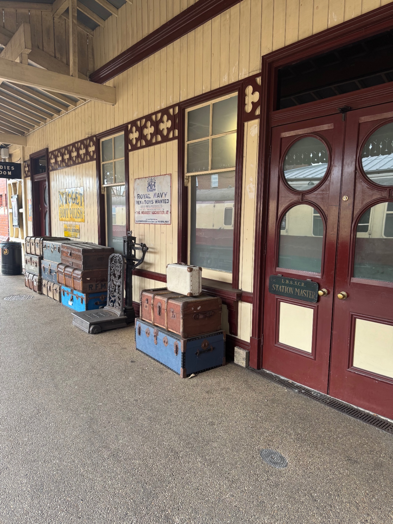Restored Victorian country railway station platform with vintage trunks and station master's office