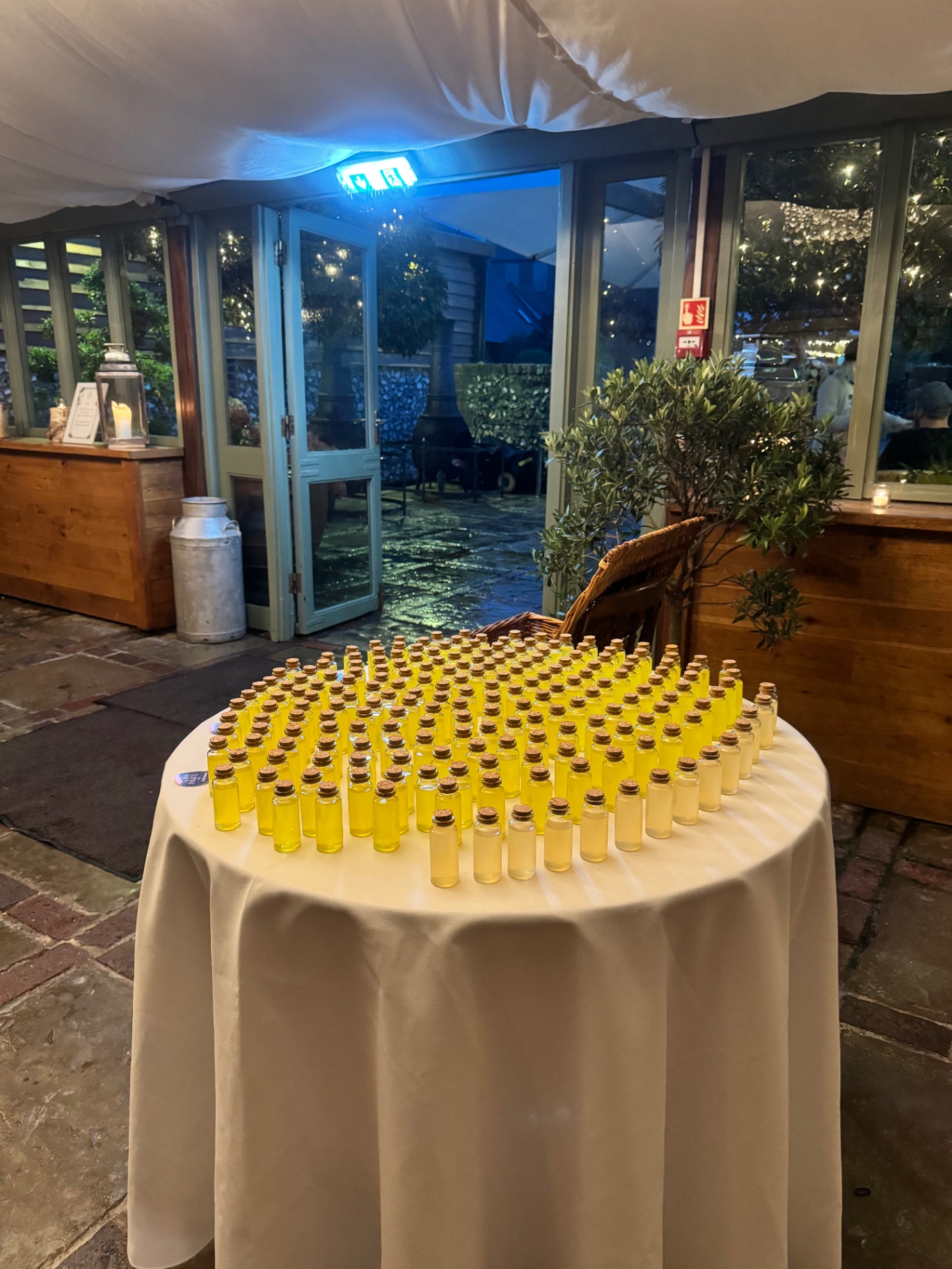 Table of miniature bottles of homemade limoncello favours arranged for guests to take home at the end of the night