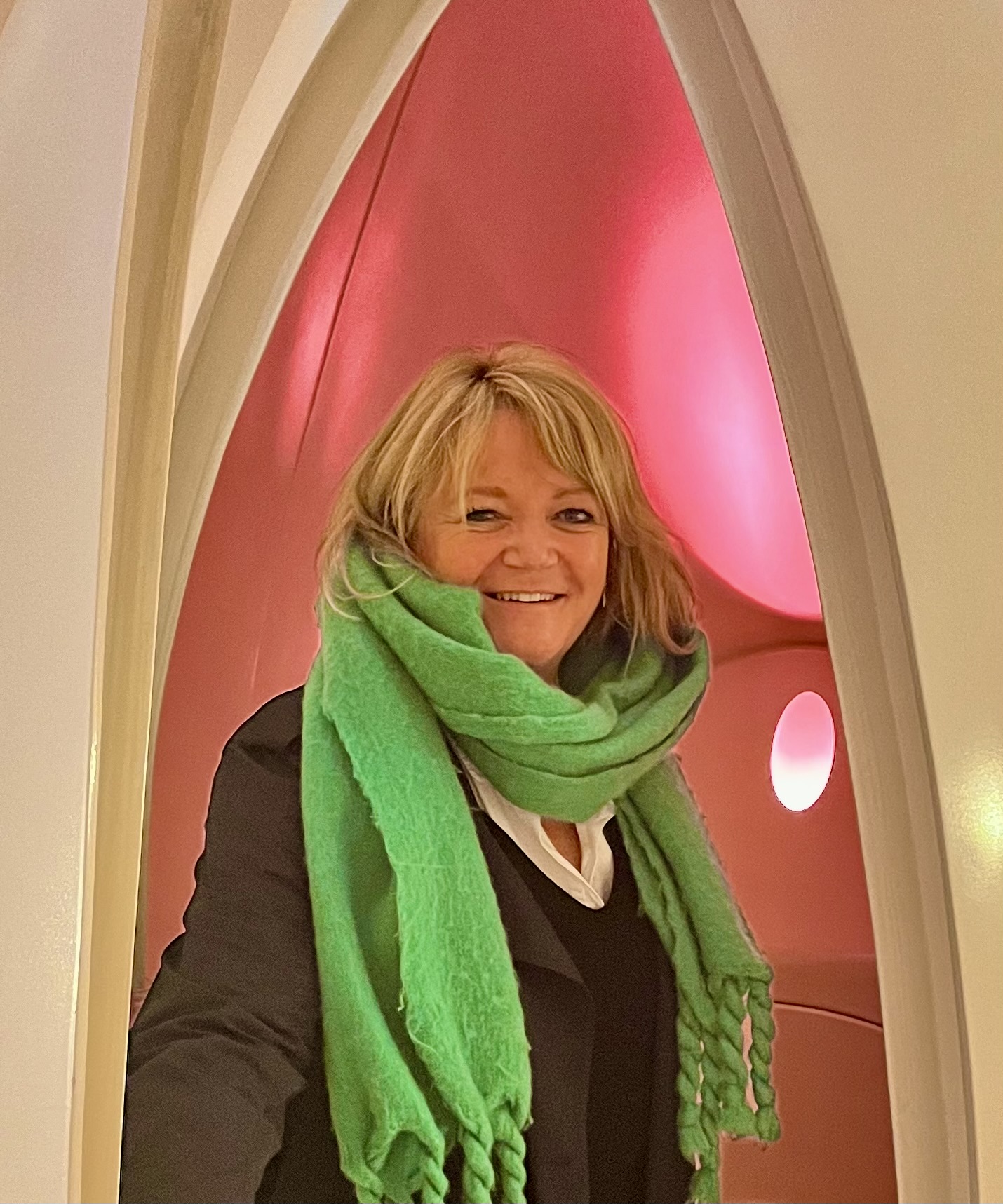 Charlie framed by a bright pink arched doorway